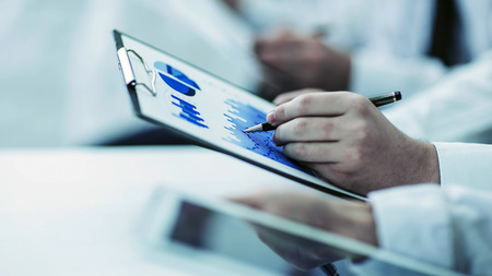 business team using digital tablet performs analysis of marketing graphics