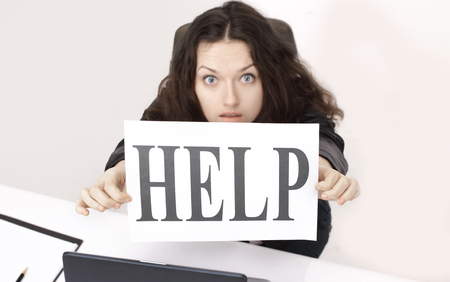 business woman sitting in front of an open notebook and holding