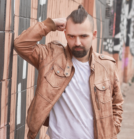 young man standing near a brick building.の写真素材