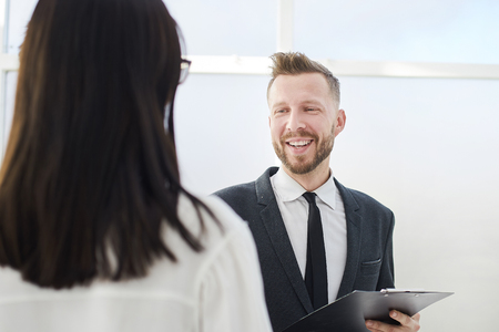 close up.smiling businesswoman with clipboard standing in the officeの写真素材
