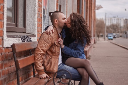 romantic couple in love kissing, sitting on the bench