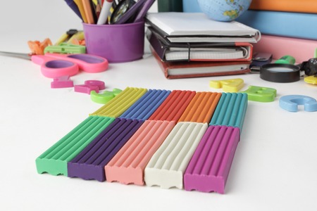 close up.pieces of plasticine and school supplies isolated on white background