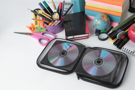 stack of CDs and school supplies isolated on white background.photo with copy spaceの写真素材