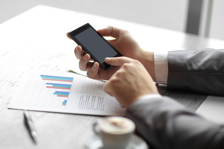 close up.the businessman uses his smartphone to check financial dataの写真素材