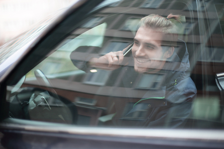 young man talking on mobile phone in the carの写真素材