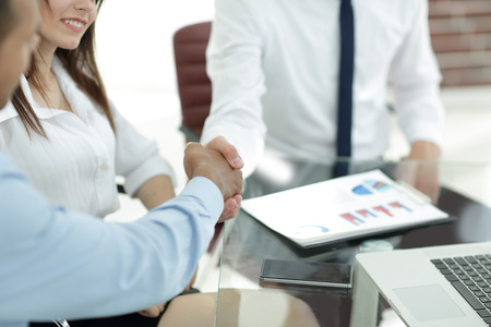 handshake of business partners on the background of the desktopの写真素材