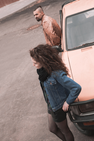 frustrated man and woman standing near the carの写真素材