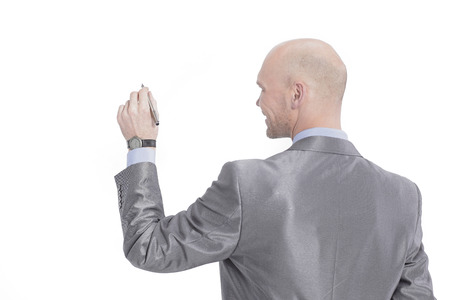 rear view.serious businessman pointing a marker at the virtualの写真素材