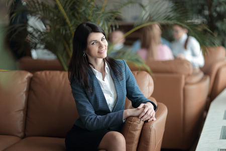 portrait of an Executive business woman with a clipboard on the background of the business centerの写真素材