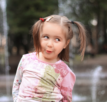pretty little girl on the background of the city fountain
