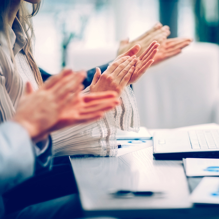 Close-up of business people clapping hands. Business seminar