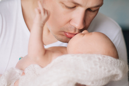 loving father kisses his pretty newborn daughterの写真素材