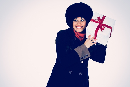 Beautiful woman with a gift in the hands, trying to guess whats in the boxの写真素材