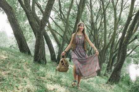 young hippie woman walking in spring forestの写真素材
