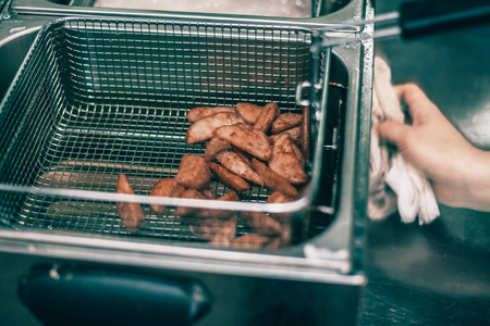 close up. Female chef preparing french fries in kitchenの写真素材