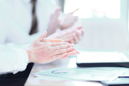 closeup. professional business team applauding the speaker, sitting at their Desk in the officeの写真素材