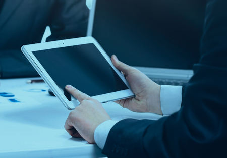 Close-up of a modern business team using tablet computer to workの写真素材