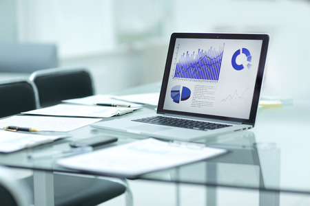 laptop, clipboard and financial data on the businessman's Desk.の写真素材