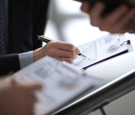 Close up of business people hands pointing growing financial business graphの写真素材
