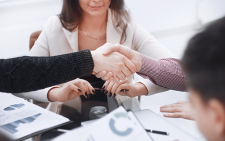 Handshake of the Manager and the client at the table in the Bank office