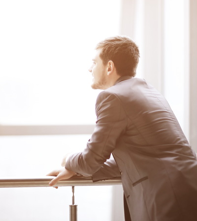 Businessman standing near the window and looking into itの写真素材