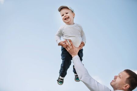 father and son on a background of blue sky.