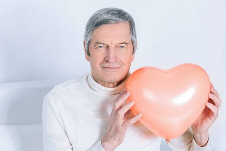 Elderly man showing a big heart.