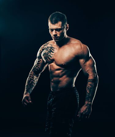 Portrait of athletic male bodybuilder isolated on blackの写真素材
