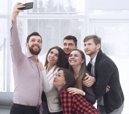 Creative business group takes selfies in a modern office