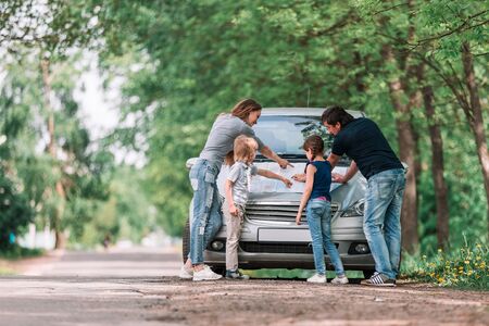 family with children discusses a paper card during a family tripの写真素材