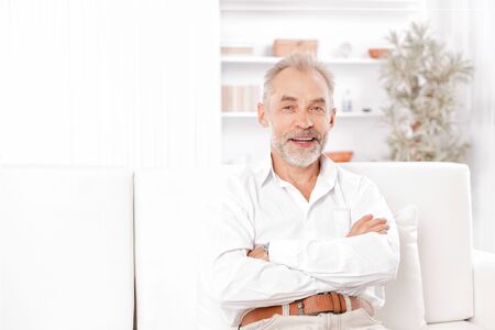 smiling businessman sitting on sofa in office