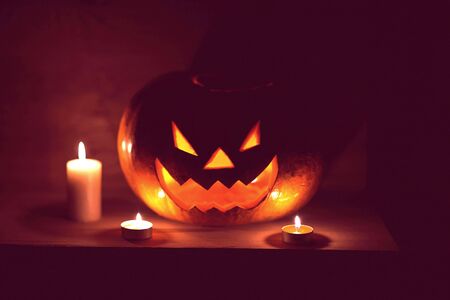 candles and pumpkin for Halloween in a cramped roomの写真素材