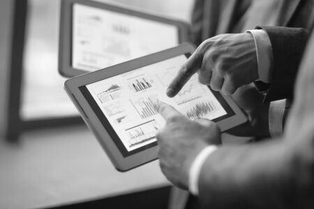 close up.two businessmen discussing financial data using a digiの写真素材