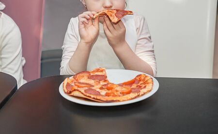 close up. little girl cook eat pizza .