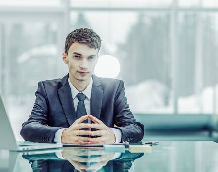young aspiring businessman sitting at a Desk before an open laptの写真素材