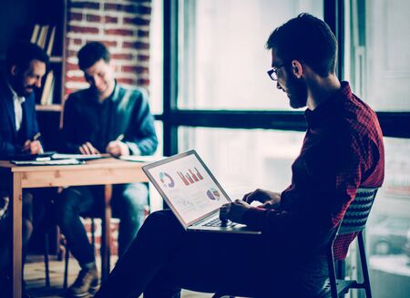 commercial Director working with financial graphs on the laptopの写真素材