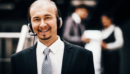 Young customer service operator talking on the headset, smiling.の写真素材