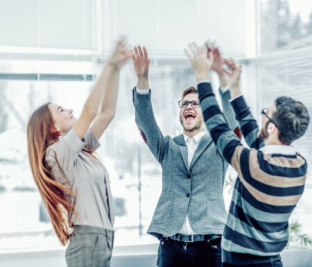 concept of victory - the jubilant business team standing in a ciの写真素材