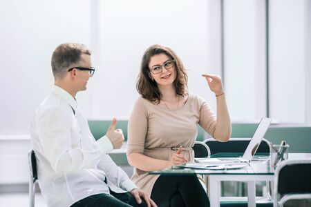 side view. business colleagues discuss something sitting at the Deskの写真素材