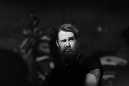 dreaming bearded man biker sitting in a chair.の写真素材