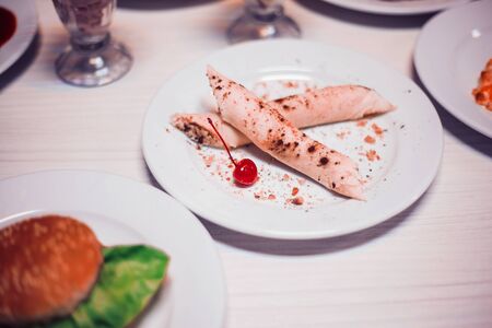 crepes with cottage cheese filling and hamburger on the table in the cafeの写真素材