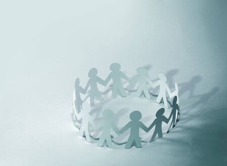 Team of paper doll people holding handsの写真素材