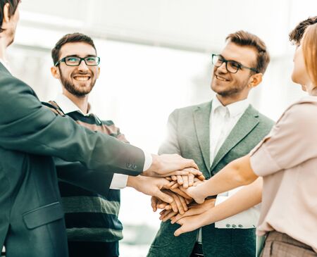 friendly business team standing and stacked hands