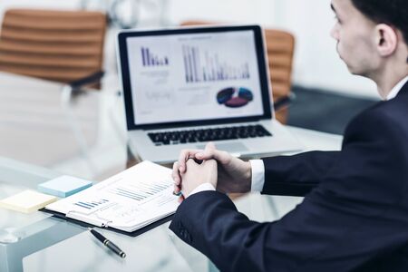 Manager of the company sitting in front of the open laptop and working with financial informationの写真素材