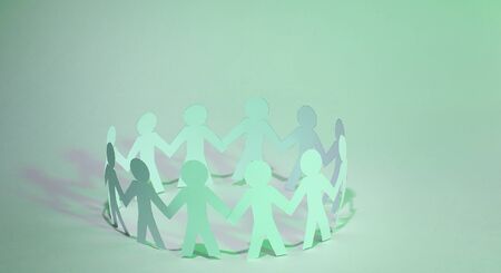 Team paper men standing holding hands.の写真素材