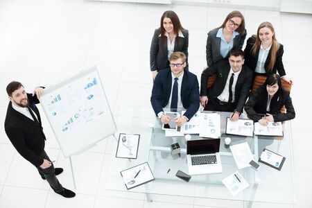 Business coach teaching employees on whiteboard at corporate training