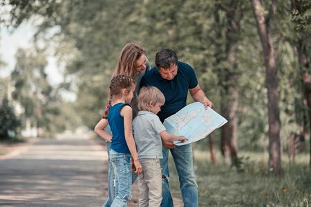 Family with their children discussing the route on the mapの写真素材