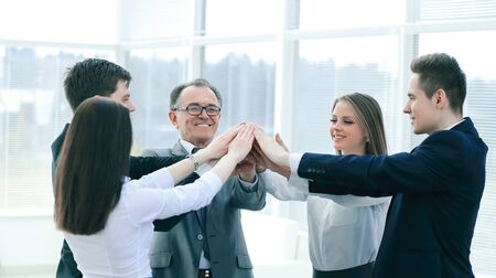 Boss and business team joining hands togetherの写真素材