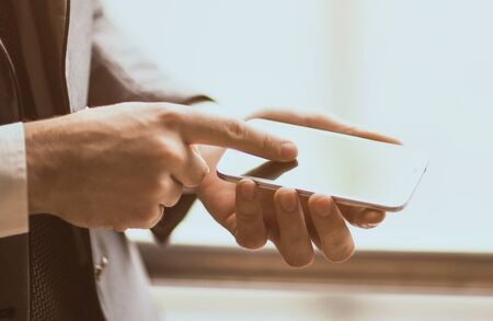 Close up man using mobile smart phone outdoorの写真素材