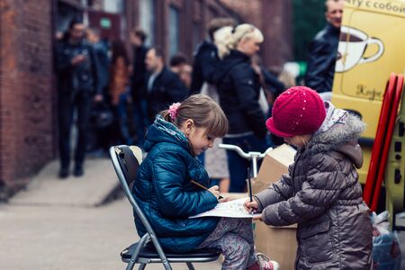 Belarus, Minsk, may 17, 2015, Oktyabrskaya street, biker festival. children draw sitting on a city street.のeditorial素材